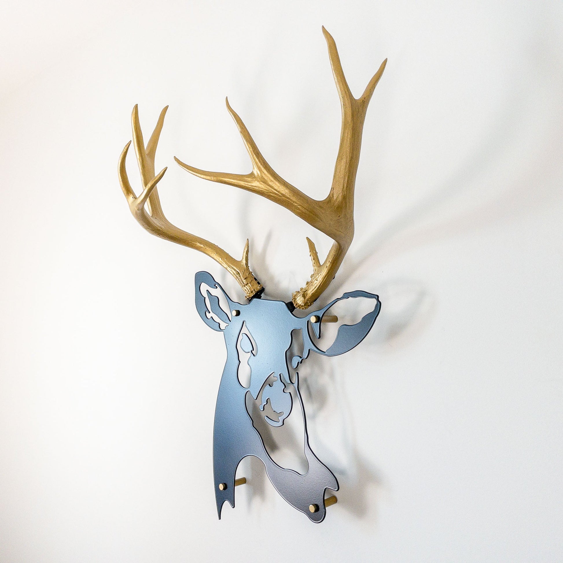 A metal wall decor made from real ethically sourced  Mule Deer antlers mounted on a metal head