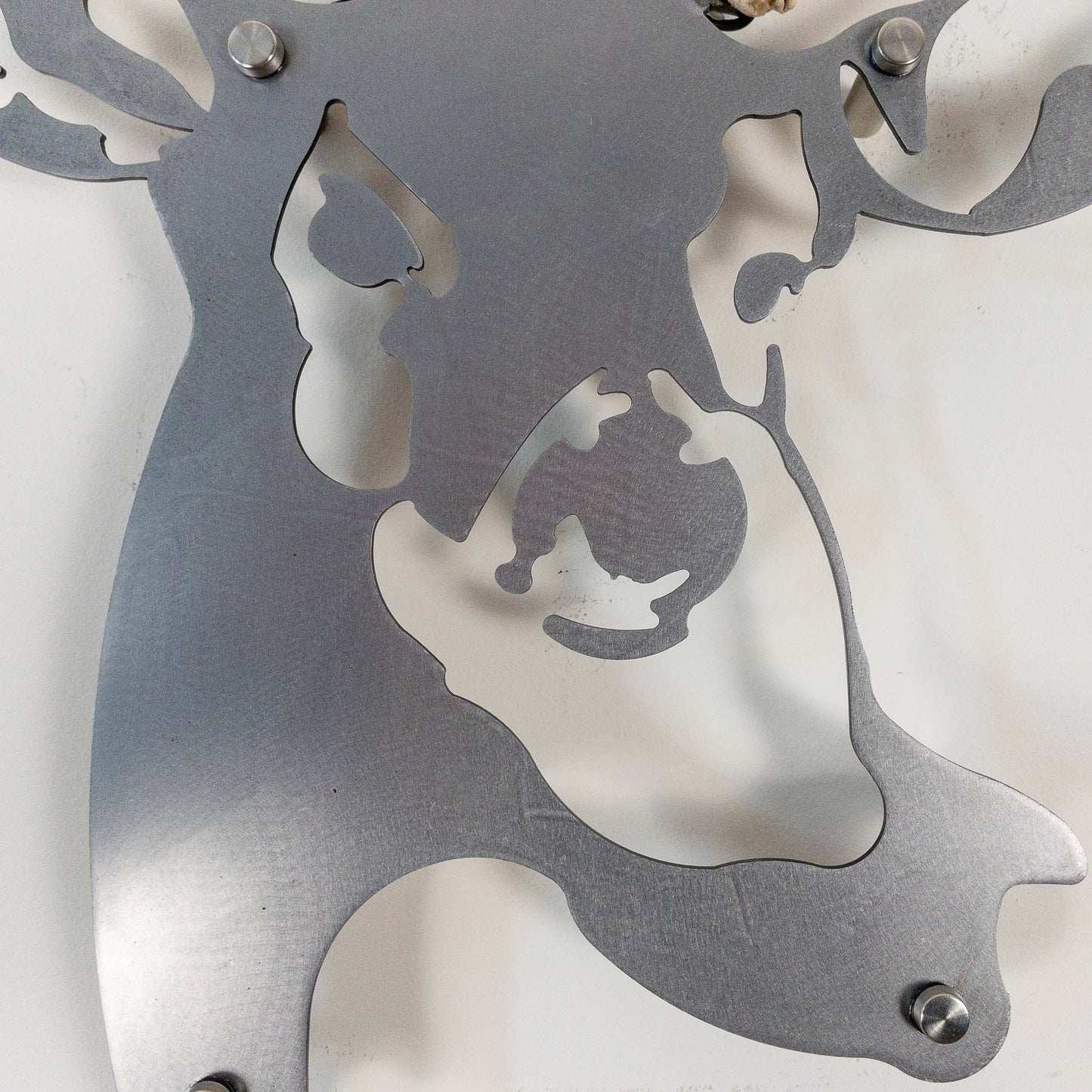 A metal wall decor made from real shed Mule Deer antlers mounted on a metal head