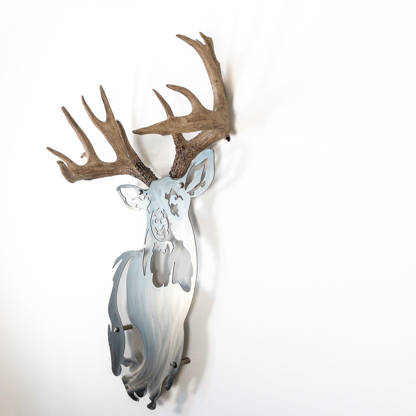 A metal wall decor made from real ethically sourced  White-Tailed Deer antlers mounted on a metal head