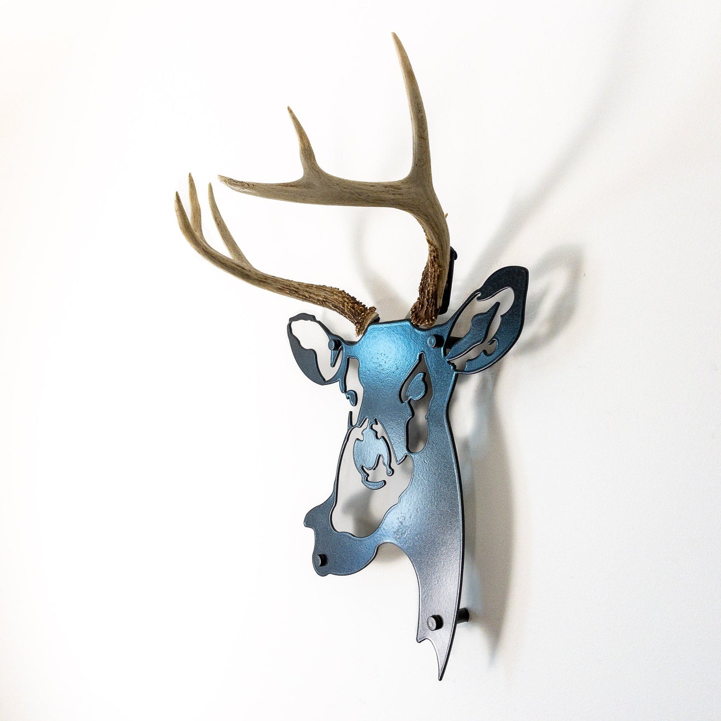 A metal wall decor made from real ethically sourced  White-Tailed Deer antlers mounted on a metal head