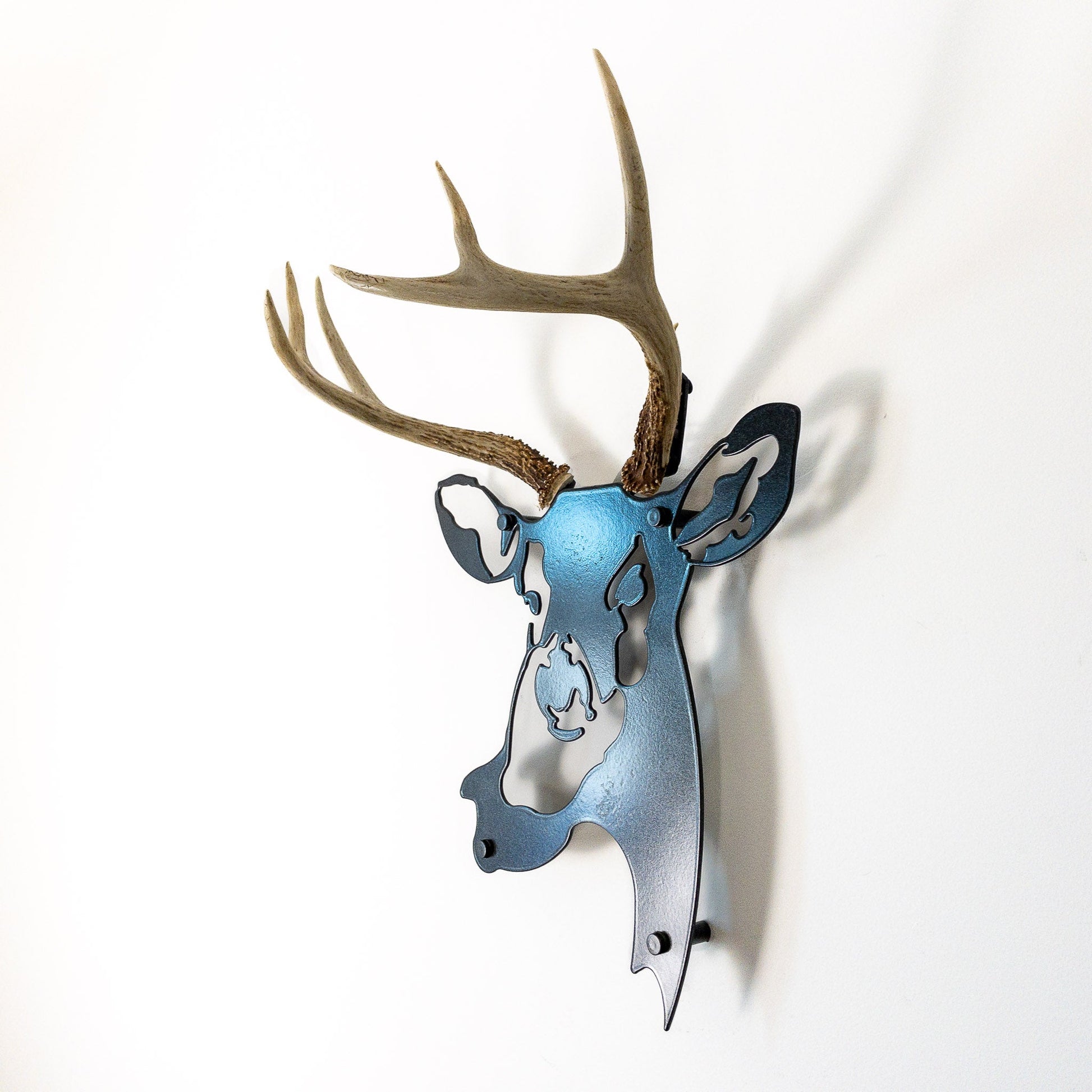 A metal wall decor made from real ethically sourced  White-Tailed Deer antlers mounted on a metal head
