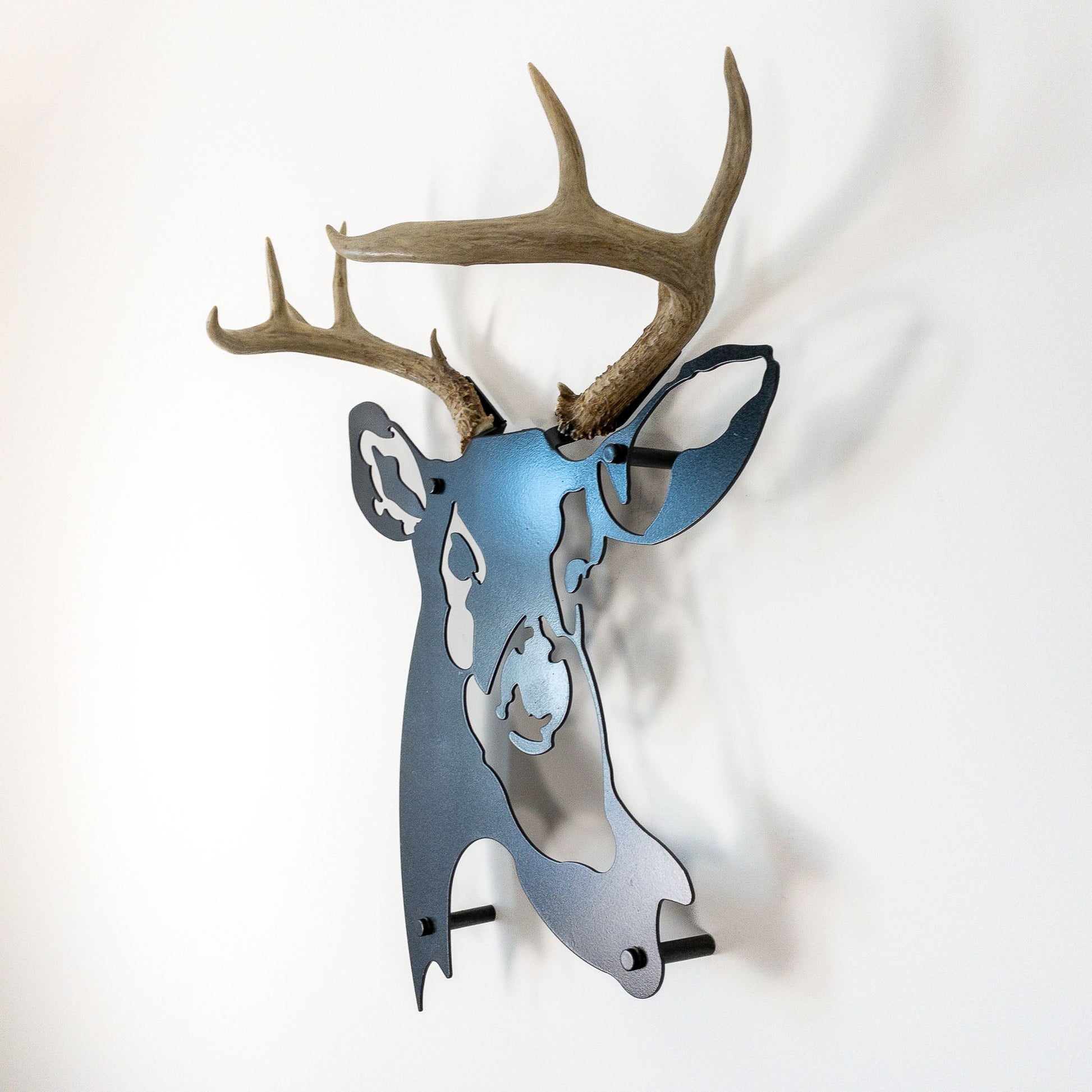 A metal wall decor made from real ethically sourced  White-Tailed Deer antlers mounted on a metal head