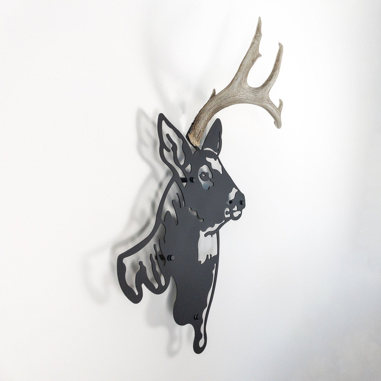 A metal wall decor made from real shed White-Tailed Deer antlers mounted on a metal head