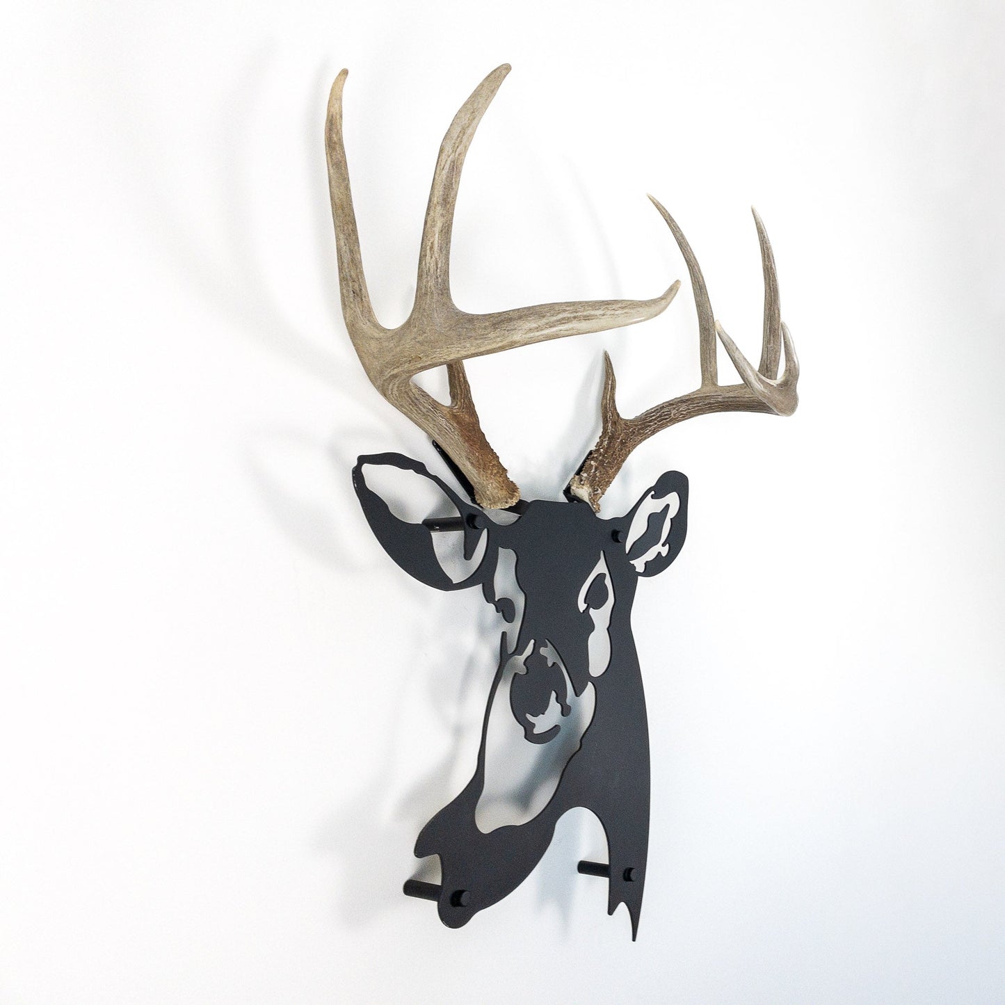 A metal wall decor made from real shed White-Tailed Deer antlers mounted on a metal head