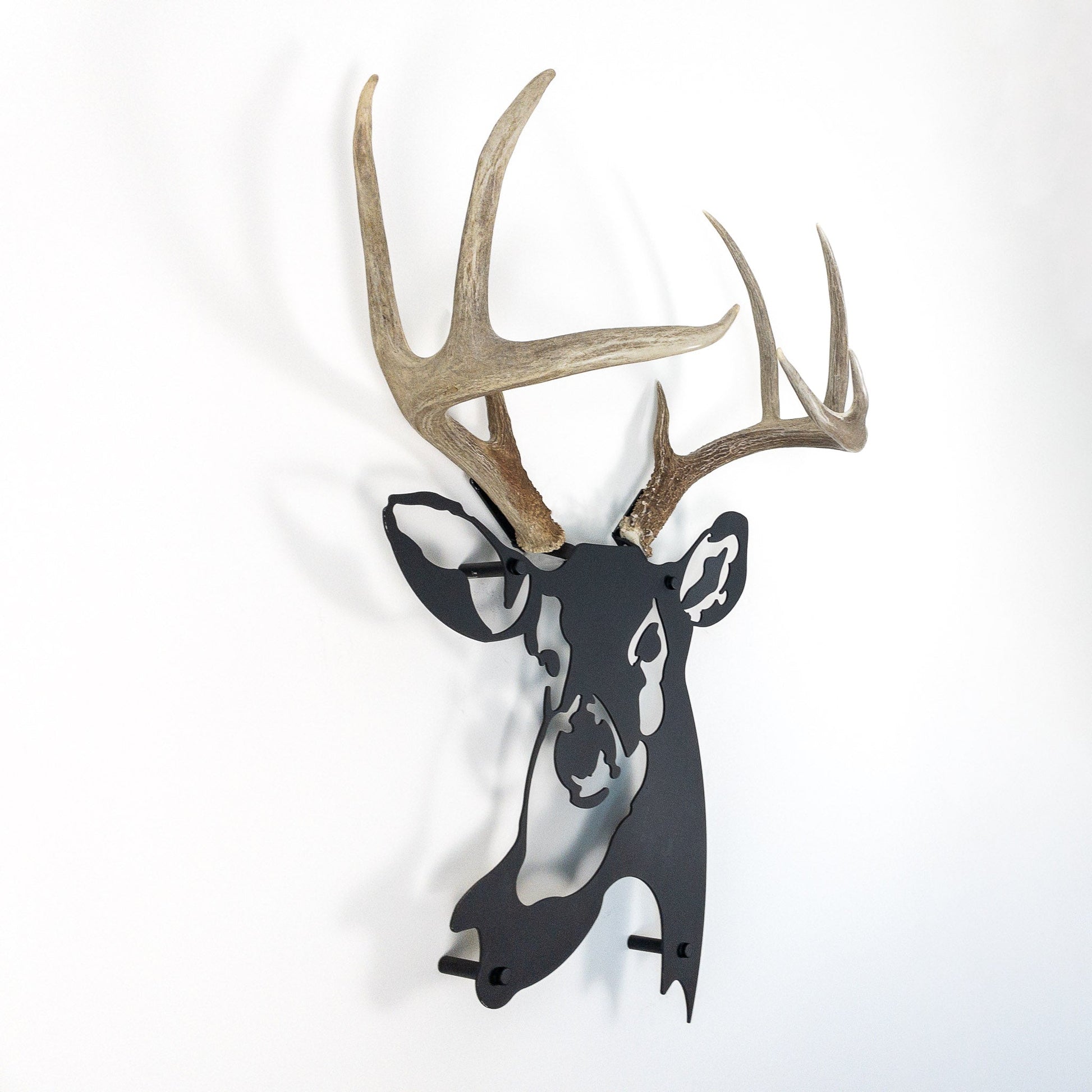 A metal wall decor made from real shed  White-Tailed Deer antlers mounted on a metal head