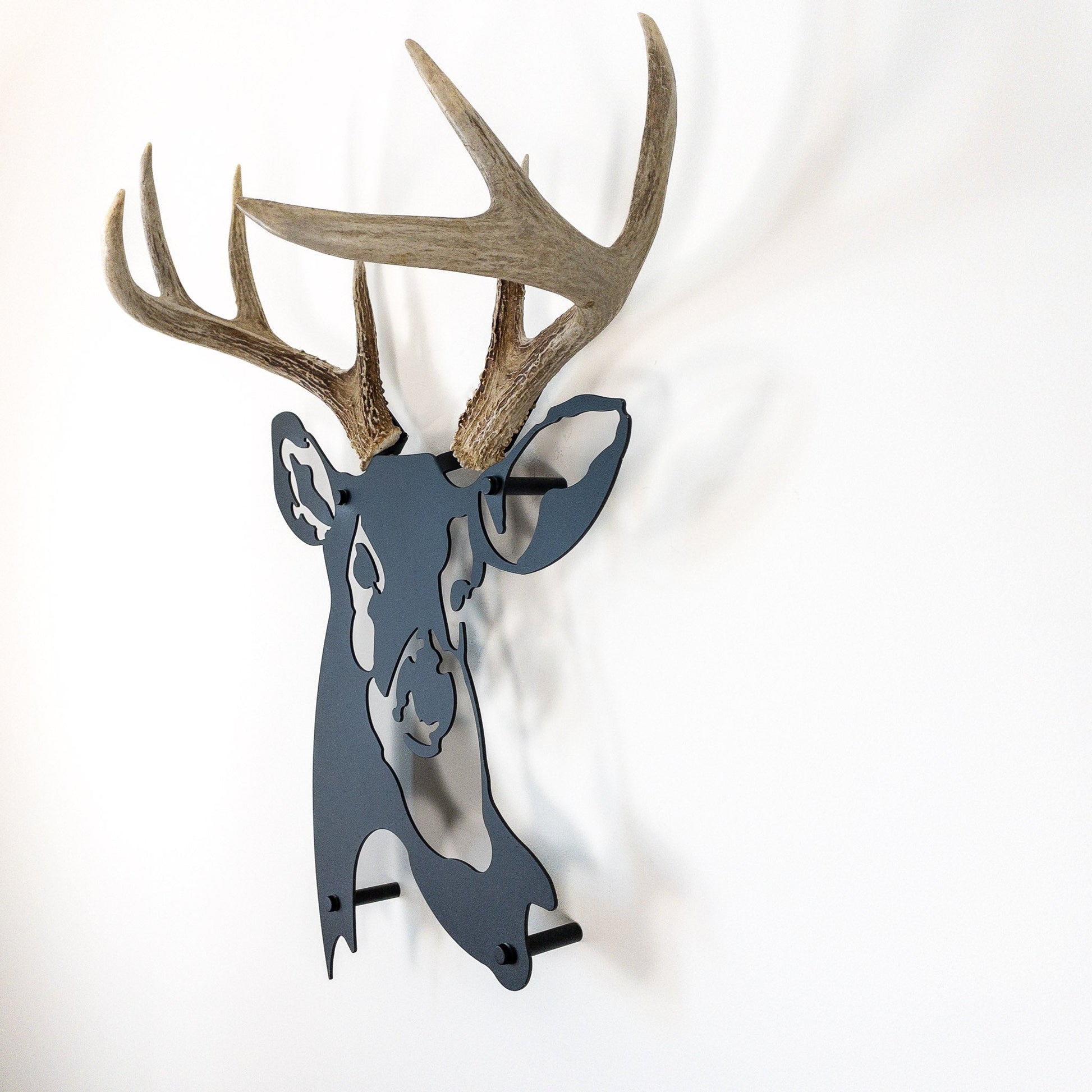 A metal wall decor made from real shed  White-Tailed Deer antlers mounted on a metal head